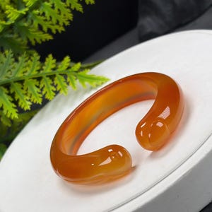 Öppet armband i orange agat: 52+ mm handskuren kanin med isiga, genomskinliga drakefjäll