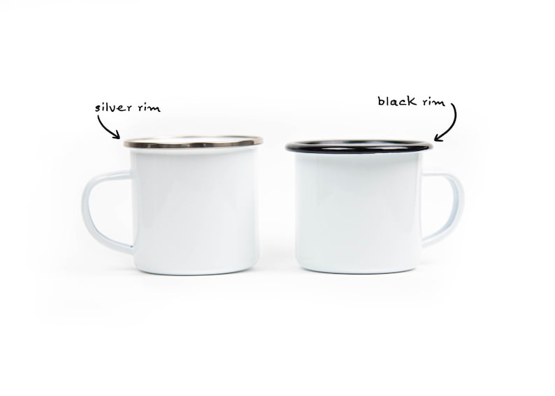 May include: Two white enamel mugs with a simple design. One mug has a silver rim, and the other has a black rim. Both mugs have a white handle and are set against a white background. The mugs are ideal for camping or everyday use.