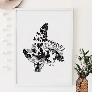 K&ouml;nnte beinhalten: Schwarz-Wei&szlig;-Kunstdruck von Nunavut, Kanada, mit detaillierten Illustrationen der Landschaft und Kultur der Region. Das Wort "NUNAVUT" steht oben auf der Karte. Der Druck ist in einem wei&szlig;en Rahmen gerahmt.