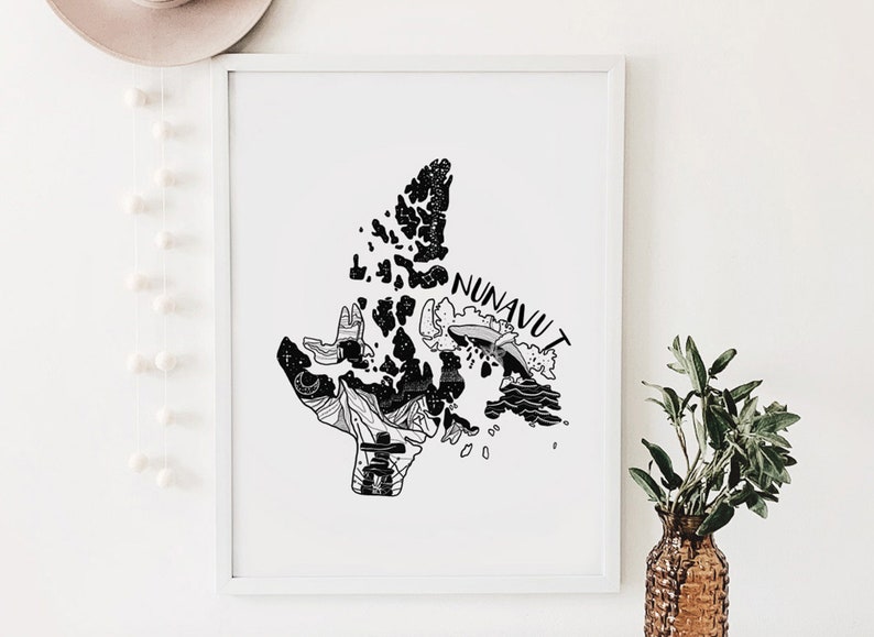 K&ouml;nnte beinhalten: Schwarz-Wei&szlig;-Kunstdruck von Nunavut, Kanada, mit detaillierten Illustrationen der Landschaft und Kultur der Region. Das Wort "NUNAVUT" steht oben auf der Karte. Der Druck ist in einem wei&szlig;en Rahmen gerahmt.