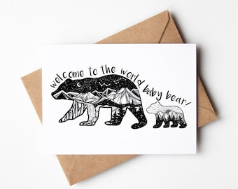 May include: A black and white greeting card with a silhouette of a bear and a baby bear. The bear's silhouette is filled with a mountain landscape and the text "welcome to the world, baby bear!" is written above the bears.