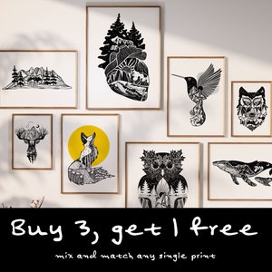 May include: A selection of framed art prints with black and white nature-themed illustrations. Designs include mountains, a heart-shaped landscape, a hummingbird, a wolf, a deer, a fox with a yellow background, an owl, and whales. The text "Buy 3, get 1 free" is also visible.