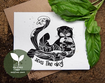 May include: A black and white illustrated greeting card featuring an otter with a wave design. The otter's body is filled with mountain and ocean imagery. The text "seas the day!" is below the otter. A green circle with text and a plant graphic is in the lower left.