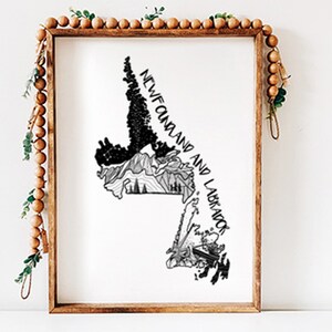 May include: A framed black and white art print of the Newfoundland and Labrador map. The print features detailed illustrations of the province's landscape, with the text "NEWFOUNDLAND AND LABRADOR" in a handwritten style. The frame is made of wood.