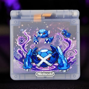 May include: A translucent handheld gaming console featuring a pixel art graphic of blue robotic creatures on the cover. The design includes purple swirling energy effects and a starry background. The word Nintendo is printed in white at the bottom.