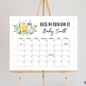 May include: A white calendar with green and gold polka dots. The calendar is for July and August and has the text "Guess the Birth Date of Baby Smith" at the top. The due date is marked on the calendar.
