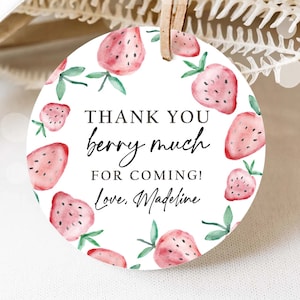 May include: Round white thank you tag with a red and green watercolor strawberry design. The text reads "Thank you berry much for coming! Love, Madeline".