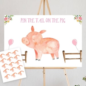 May include: A pink pig with a watercolor design stands in front of a wooden fence. The pig is looking to the left. There are two pink balloons in the background. The text "Pin the Tail on the Pig" is written in pink letters at the top of the image. There are 12 pink pig tails on a separate sheet of paper.