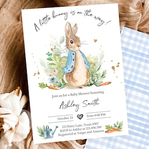 May include: Baby shower invitation featuring a watercolor illustration of a bunny in a blue jacket. The invitation includes the text "A little bunny is on the way!" and event details. A blue gingham patterned card is also visible.