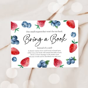 Puede incluir: Una tarjeta de invitación de baby shower imprimible con una ilustración de acuarela de fresas y arándanos. El texto dice "Una pequeña petición que no será demasiado difícil... Trae un libro En lugar de una tarjeta! No importa si está bien cuidado o nuevo, de cualquier manera tu libro le recordará al bebé de ti. Escribe un mensaje dulce en la cubierta interior y tus palabras podrán ser apreciadas una y otra vez."