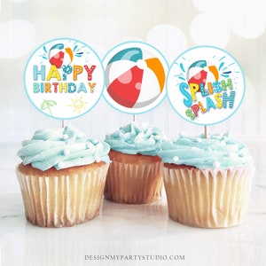 Può includere: Tre topper rotondi per cupcake a tema palla da spiaggia. Il primo topper dice "Buon compleanno" in lettere colorate con un ombrello da spiaggia e un sole. Il secondo topper presenta una palla da spiaggia colorata. Il terzo topper dice "Splish Splash" in lettere colorate con una palla da spiaggia.