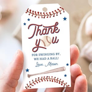 Puede incluir: Una etiqueta de regalo con temática de béisbol con las palabras "Thank You" en escritura roja y azul, un gráfico de béisbol y el mensaje "For swinging by, we had a ball!". La etiqueta también incluye una ilustración de bate de béisbol y el nombre "Mason".