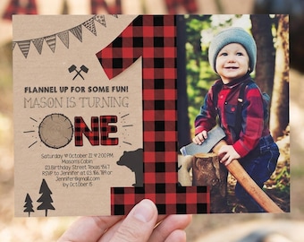 May include: A rectangular birthday invitation card featuring a large red and black buffalo plaid number one. The design includes a photograph of a child in a plaid shirt and beanie, text reading FLANNEL UP FOR SOME FUN, and tree graphics.