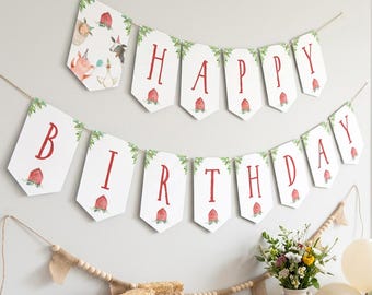May include: A two-tiered banner spelling HAPPY BIRTHDAY with white pennants featuring red letters, green foliage, and small red barn illustrations. The banner is strung on twine and hangs above a table with farm-themed cookies and decor.