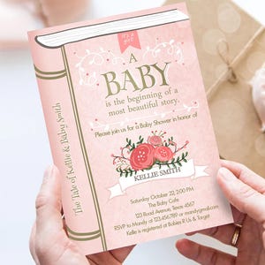 May include: Pink baby shower invitation with a book design. The text reads "The Tale of Kellie & Baby Smith. It's a girl! A Baby is the beginning of a most beautiful story." The invitation includes details for the baby shower, including the date, time, location, and RSVP information.