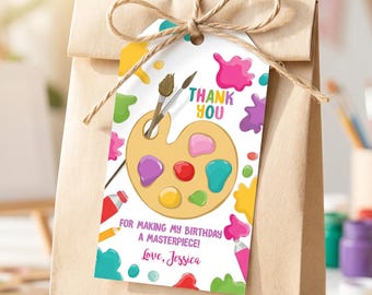 May include: A rectangular white gift tag tied with brown twine to a brown paper bag. The tag features a yellow paint palette with brushes, colorful paint splatters, and the text: THANK YOU FOR MAKING MY BIRTHDAY A MASTERPIECE! Love, Jessica.