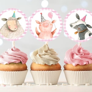 May include: Three pink and white striped cupcake toppers with farm animal illustrations. The toppers feature a pig, a sheep, and a cow, each wearing a party hat.