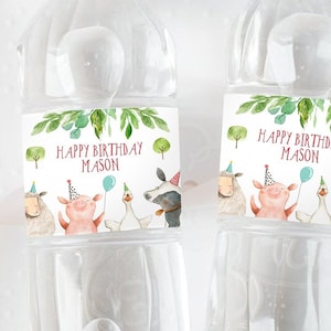 May include: Two clear plastic water bottles with labels that say "Happy Birthday Mason" and feature a watercolor illustration of farm animals. The labels have a green leafy border and a pink background.