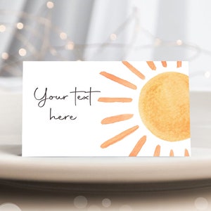 May include: A white card with a watercolor illustration of a sun with orange rays. The text "Your text here" is written in black cursive.