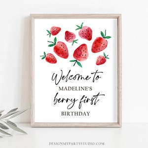 Peut inclure: Une affiche imprimable blanche avec un cadre en bois. L'affiche pr&eacute;sente une illustration aquarelle de fraises rouges et le texte "Bienvenue au premier anniversaire de Madeline's berry".