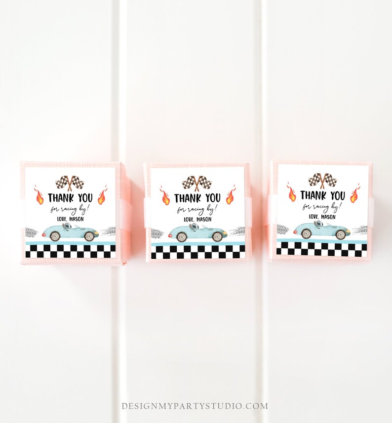 Puede incluir: Tres cajas de regalo rosas con etiquetas blancas. Las etiquetas tienen un patr&oacute;n a cuadros, un coche de carreras azul y el texto "&iexcl;Gracias por correr! Con cari&ntilde;o, Mason".