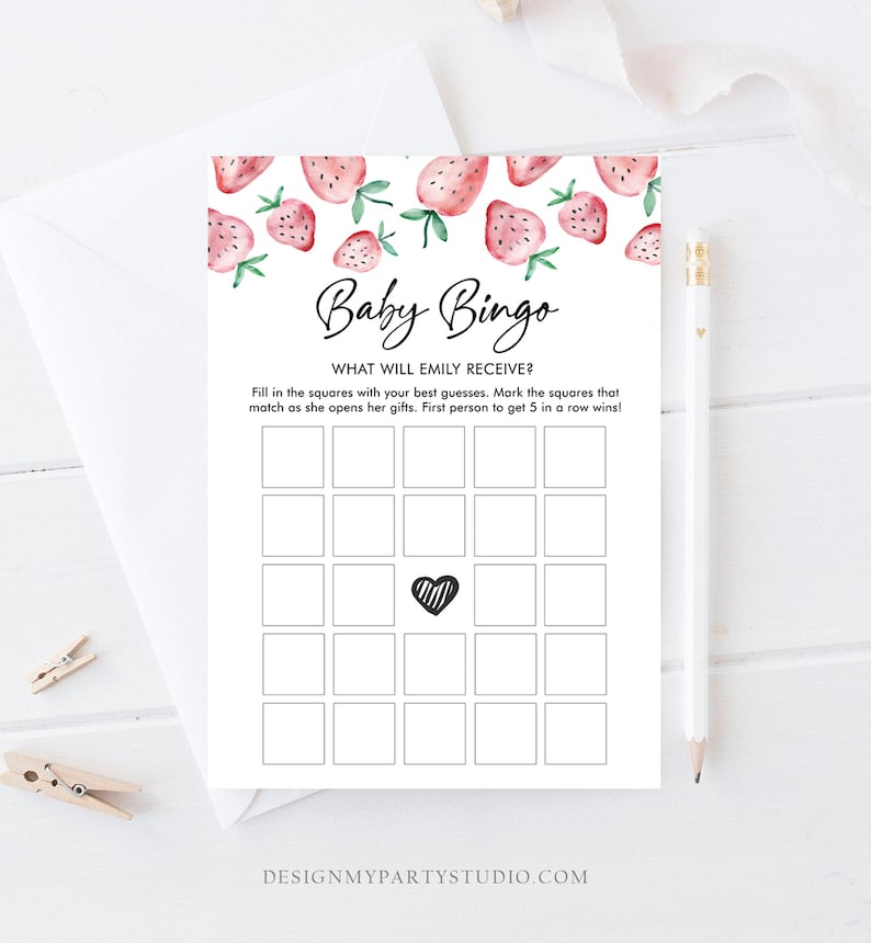 May include: A white Baby Bingo game card with a strawberry design. The card has a grid of squares, a heart in the center, and the text "Baby Bingo" and "What will Emily receive?" at the top. A pencil and envelope are in the background.