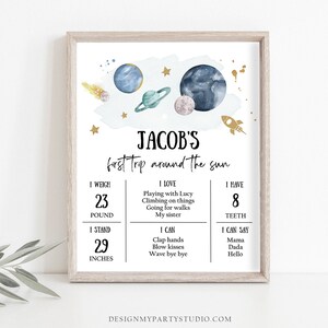 May include: A blue and white illustrated poster with a space theme. The poster says "Jacob's first trip around the sun". It includes details about Jacob's weight, height, number of teeth, and things he loves and can do.