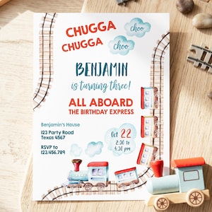 May include: A rectangular birthday invitation card featuring watercolor train tracks, a steam engine, and train cars. Text includes CHUGGA CHUGGA, BENJAMIN is turning three!, ALL ABOARD THE BIRTHDAY EXPRESS, date Oct 22, time 2:30 to 4:30 pm, and address details.