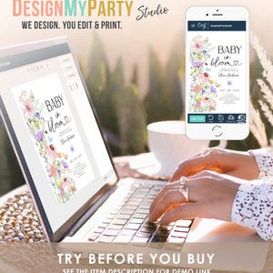 May include: A laptop computer displaying a baby shower invitation with a floral design and the text "Baby in Bloom". The invitation is being edited on a design platform. The text "Try Before You Buy" is displayed below the laptop.