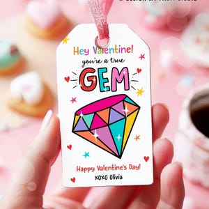 May include: A white Valentine's Day gift tag with a colourful diamond illustration and the text "Hey Valentine! You're a true GEM. Happy Valentine's Day! XOXO Olivia."