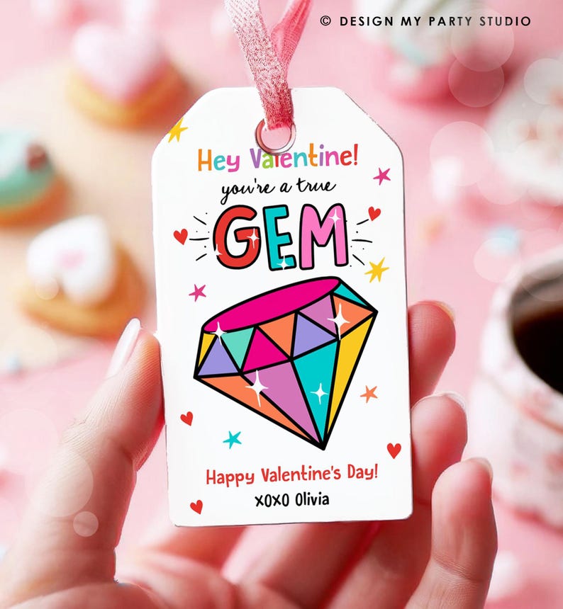 May include: A white Valentine's Day gift tag with a colourful diamond illustration and the text "Hey Valentine! You're a true GEM. Happy Valentine's Day! XOXO Olivia."