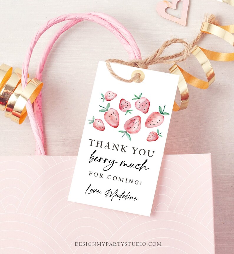 May include: A white gift tag with watercolor strawberries and the text "Thank You berry much for coming! Love, Madeline." The tag is tied with twine and is attached to a pink gift bag with gold ribbon.