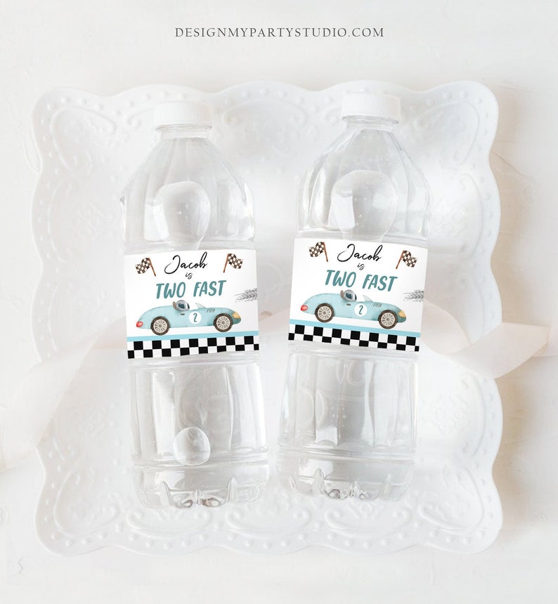Puede incluir: Dos botellas de agua con etiquetas que dicen "Jacob is Two Fast" y presentan un coche de carreras azul de dibujos animados con una bandera a cuadros. Las etiquetas son negras y blancas con texto marr&oacute;n.