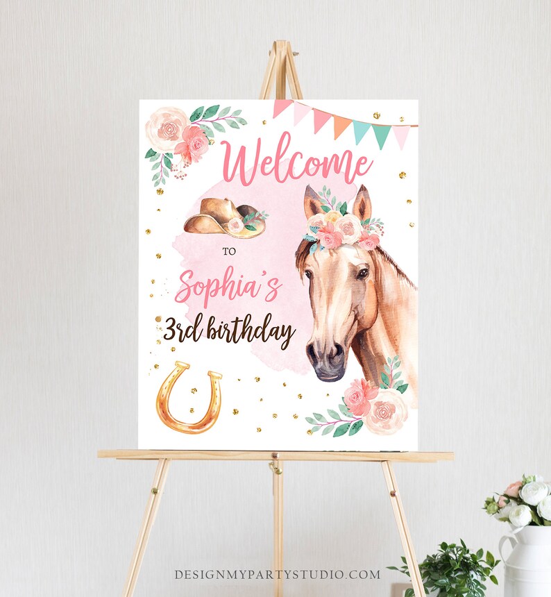 May include: Welcome to Sophia's 3rd birthday party sign with a pink background, a horse with a floral crown, a cowboy hat, a horseshoe, and gold glitter.