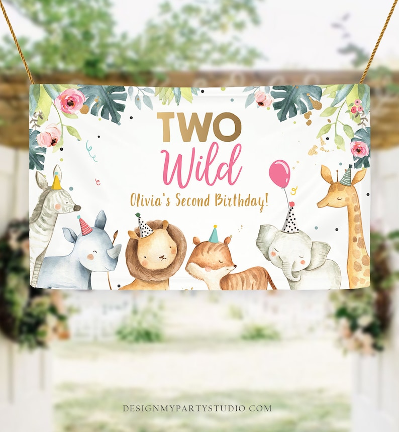 May include: A white banner with the text "TWO Wild Olivia's Second Birthday!" in pink and gold lettering. The banner features a jungle theme with illustrations of a zebra, rhinoceros, lion, tiger, elephant, and giraffe.