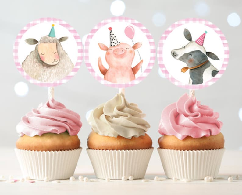 May include: Three pink and white striped cupcake toppers with farm animal illustrations. The toppers feature a pig, a sheep, and a cow, each wearing a party hat.