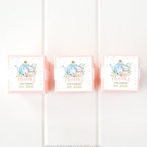 May include: Three pink favour boxes with white labels. The labels feature a blue teapot and teacups with floral accents. The text on the labels reads "Thanks for coming! Love, Jessica."