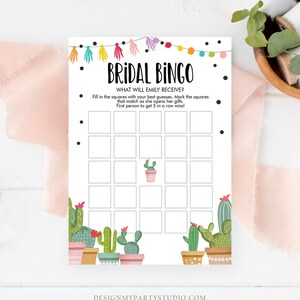 K&ouml;nnte beinhalten: Braut-Bingo-Spielkarte mit dem Text "BRIDAL BINGO" und "WHAT WILL EMILY RECEIVE?". Die Karte zeigt ein Raster f&uuml;r Vermutungen, Kaktusillustrationen und farbenfrohe Lichterketten. Der untere Teil der Karte lautet "DESIGNMYPARTYSTUDIO.COM".
