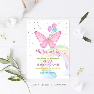 K&ouml;nnte beinhalten: Ein rosa Schmetterling mit Regenbogenfl&uuml;geln und einem Regenbogenhintergrund. Der Schmetterling h&auml;lt Ballons und der Text "Flutter on by" befindet sich &uuml;ber dem Schmetterling. Der Text "For some birthday fun Olivia is turning one!" befindet sich unter dem Schmetterling. Der Text "Saturday, June 22, 3:00 PM - 4:00 PM" befindet sich unter dem Text "Olivia is turning one!" Der Text "Ashley's House 123 Party Lane, Texas 4567 RSVP to Amy at 123.456.789" befindet sich unter dem Datum und der Uhrzeit. Der Text "DesignMyPartyStudio.com" befindet sich am unteren Rand der Einladung.