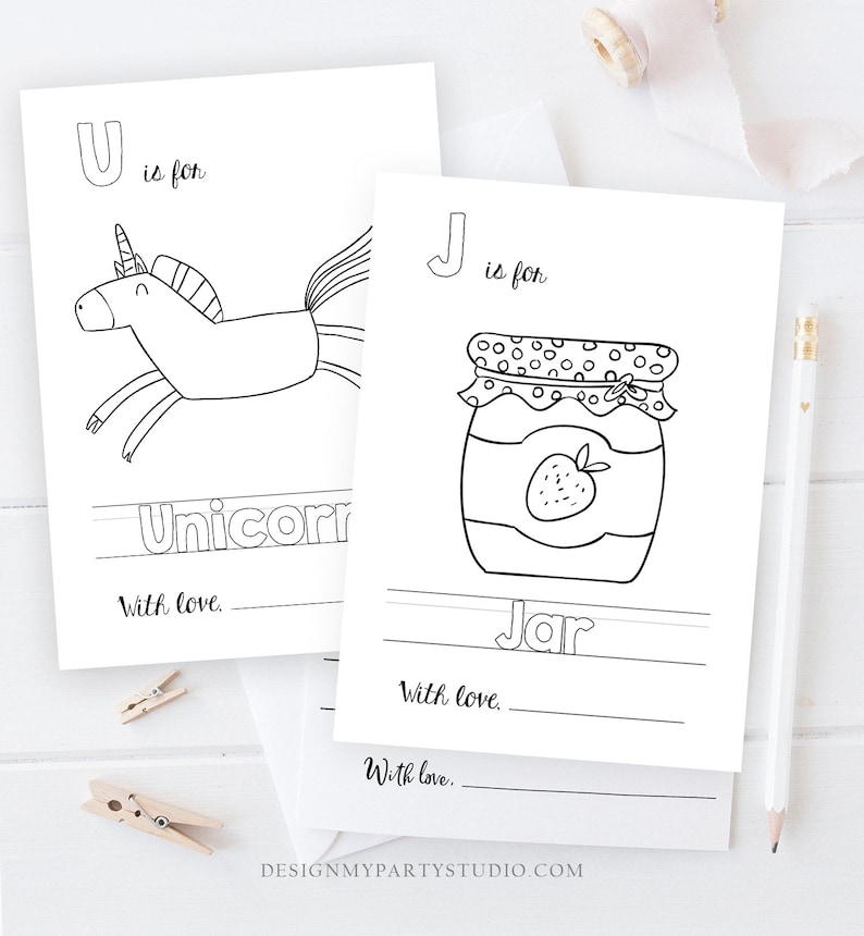 Op de afbeelding: Zwart-witte afdrukbare alfabet kleurplaten met een eenhoorn en een pot jam. De pagina's bevatten de letters U en J en de woorden "Einhorn" en "Pot jam".