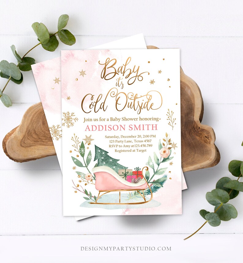 May include: Baby shower invitation with the text "Baby it's Cold Outside" in gold script. The invitation features a pink watercolor background, a pink sleigh with gifts, and floral and snowflake accents. The invitation is for Addison Smith.