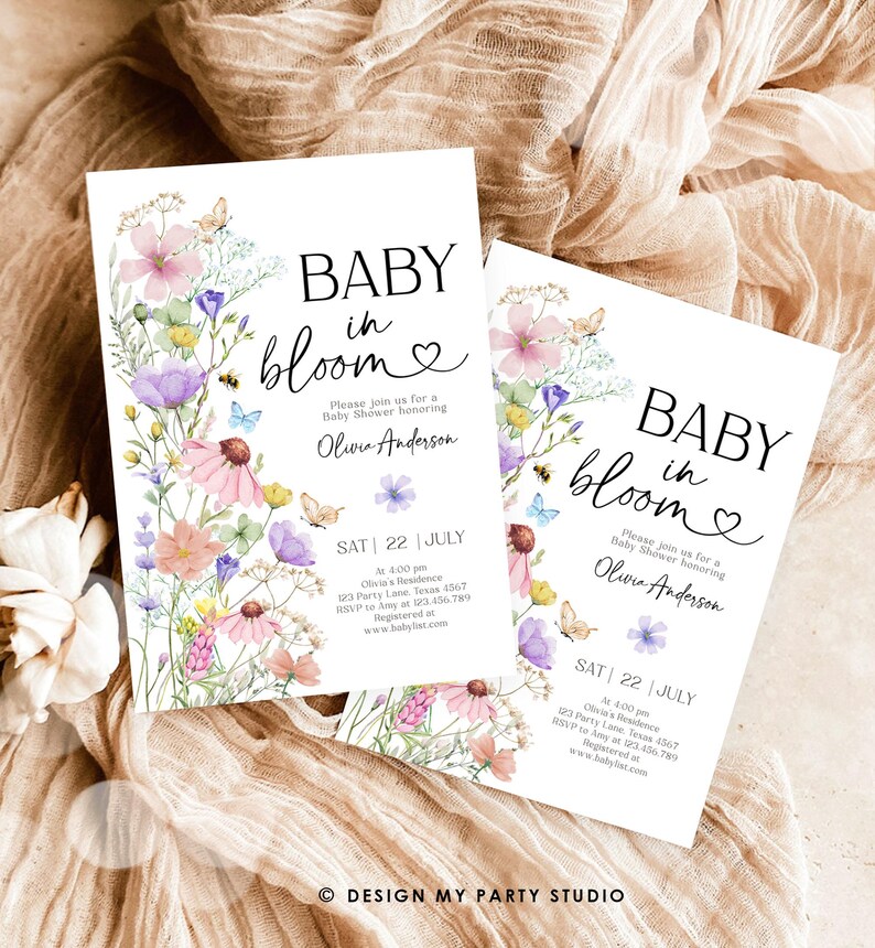 May include: A baby shower invitation with a floral design. The invitation says "Baby in Bloom" and includes the date and time of the shower. The invitation is decorated with watercolor flowers and butterflies.