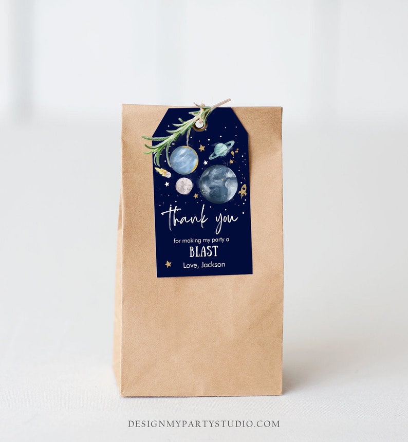 May include: A blue and gold thank you gift tag with a space theme. The tag features planets, stars, and a rocket ship. The text on the tag reads "Thank you for making my party a BLAST. Love, Jackson."