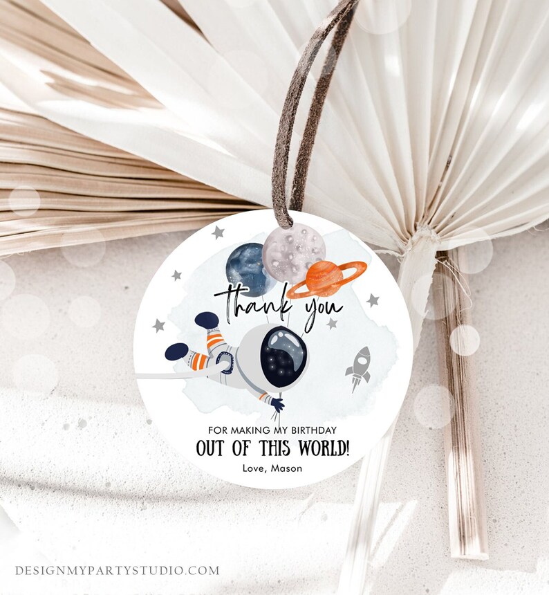May include: Round white thank you tag with an astronaut holding balloons shaped like planets. The tag says "Thank you" and "For making my birthday out of this world! Love, Mason".