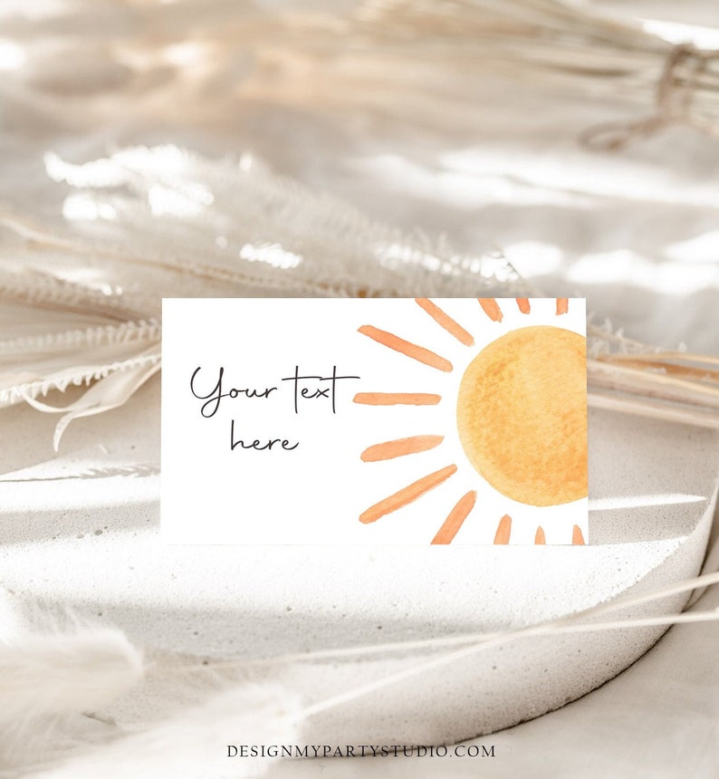 May include: A white card with a watercolor illustration of a sun with orange rays. The text "Your text here" is written on the card.