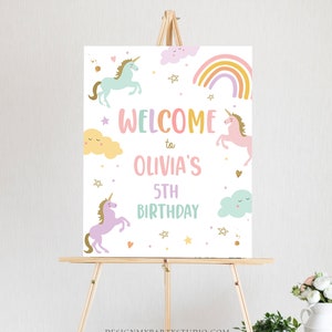 K&ouml;nnte beinhalten: Willkommen zu Olivias 5. Geburtstagsschild mit einem Regenbogen, Wolken und Einh&ouml;rnern. Das Schild ist wei&szlig; mit goldenen Glitzerakzenten.