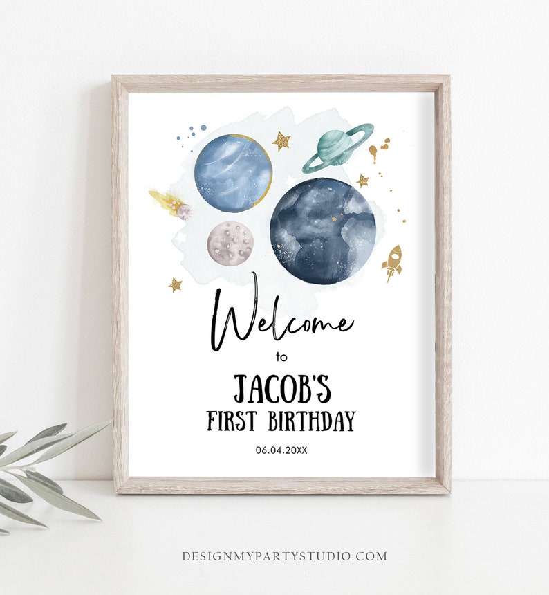 May include: A printable welcome sign for a first birthday party with a space theme. The sign features a watercolor illustration of planets, stars, and a rocket ship. The text reads "Welcome to Jacob's First Birthday 06.04.20XX".