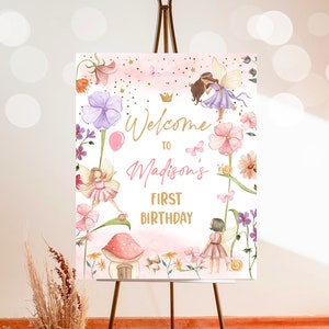 May include: Welcome to Madison's First Birthday sign with a pink and white background featuring fairies, flowers, and a mushroom house. The sign is perfect for a fairy-themed birthday party.