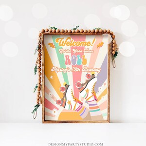 Op de afbeelding: Een retro-stijl verjaardagsfeestbord met een regenboogachtergrond en een paar rol schaatsen. Het bord zegt "Welkom! Laat de goede tijden rollen Marley's 12th Birthday".