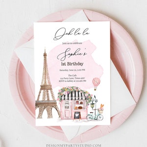Pu&ograve; includere: Un invito rosa e bianco con uno sfondo ad acquerello. L'invito dice "Oh la la" e "Unisciti a noi per festeggiare il 1&deg; compleanno di Sophie". L'invito include anche un disegno della Torre Eiffel, un caff&egrave; e una bicicletta.